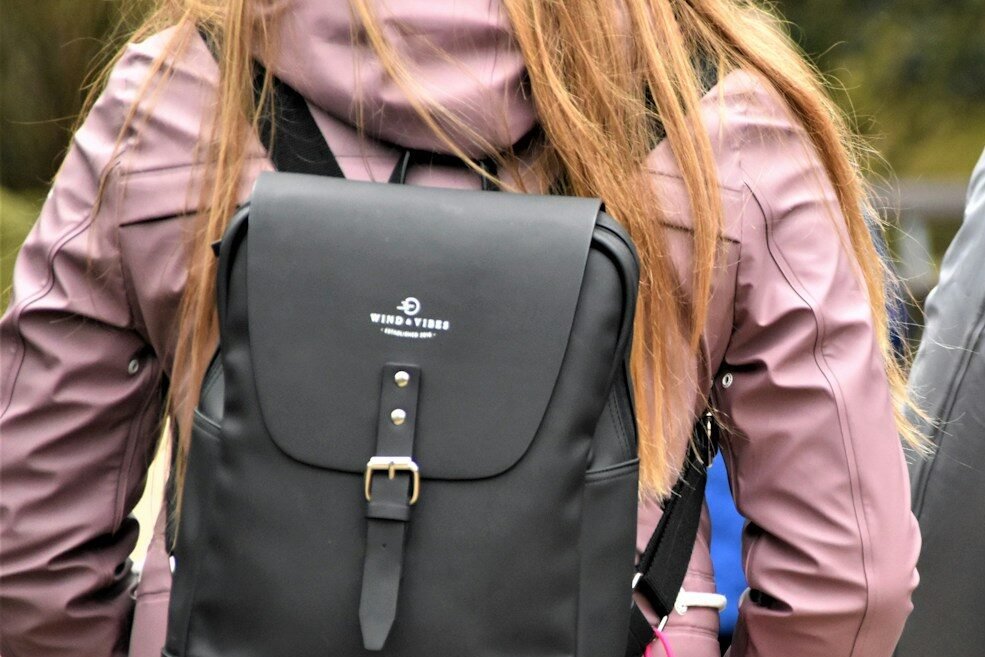 woman in black leather jacket carrying black leather backpack