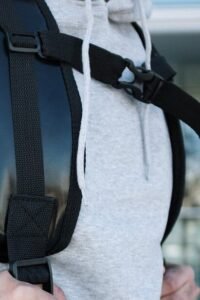 person in gray sweater with black sling bag